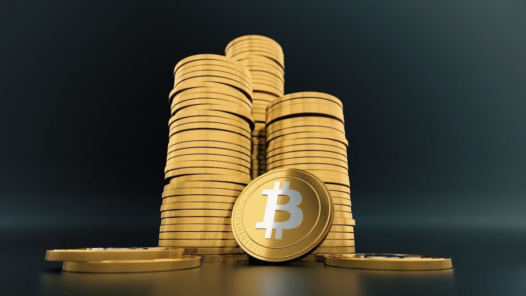 Stacks of gold Bitcoin coins symbolizing cryptocurrency wealth and digital assets on a dark background.
