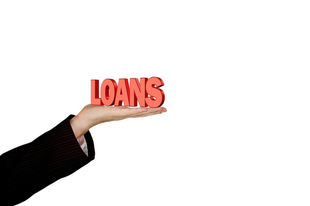 Pakistan Seeks China Loan to Boost Forex Reserves. A businessperson's hand holding the word "LOANS" in bold red letters, symbolising Pakistan’s efforts to secure financial support from China to strengthen its foreign exchange reserves.