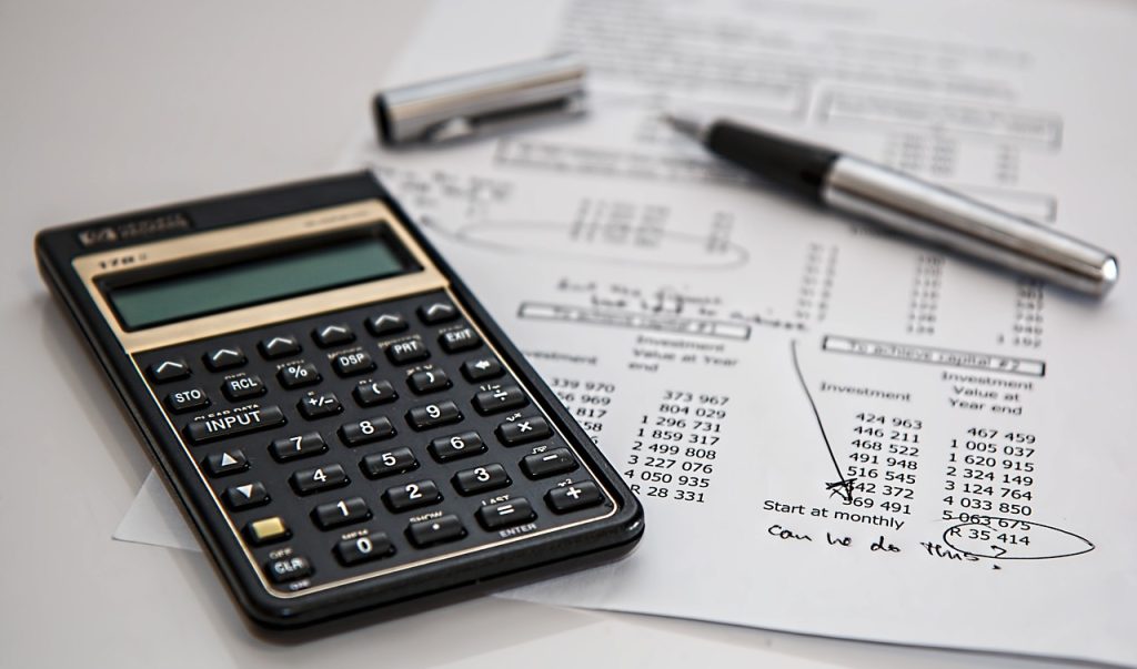 A calculator and pen on a calculation sheet.