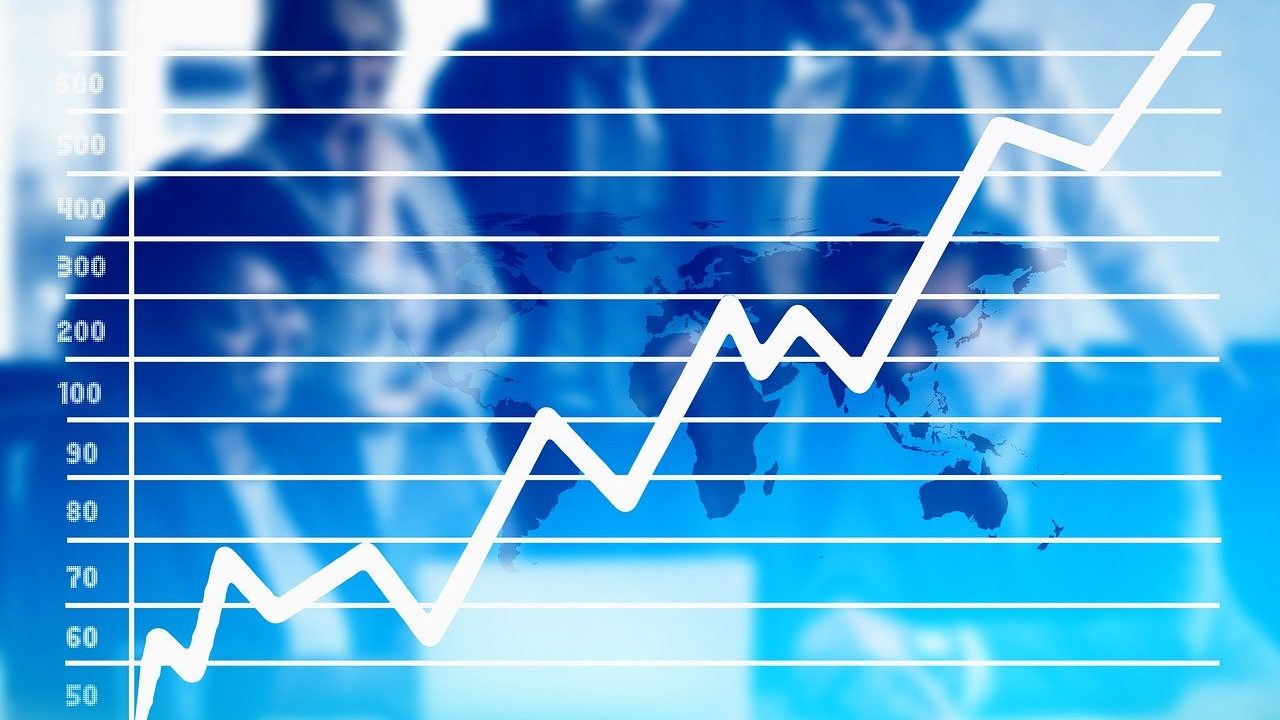 Upward-trending line graph overlayed on a global map with blurred business professionals in the background, symbolizing PSX’s record-breaking bullish surge post-budget.