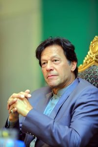 Imran Khan’s Polygraph Refusal May Hurt May 9 Trial Case – Imran Khan seated in a formal setting, wearing a traditional outfit with a serious expression.