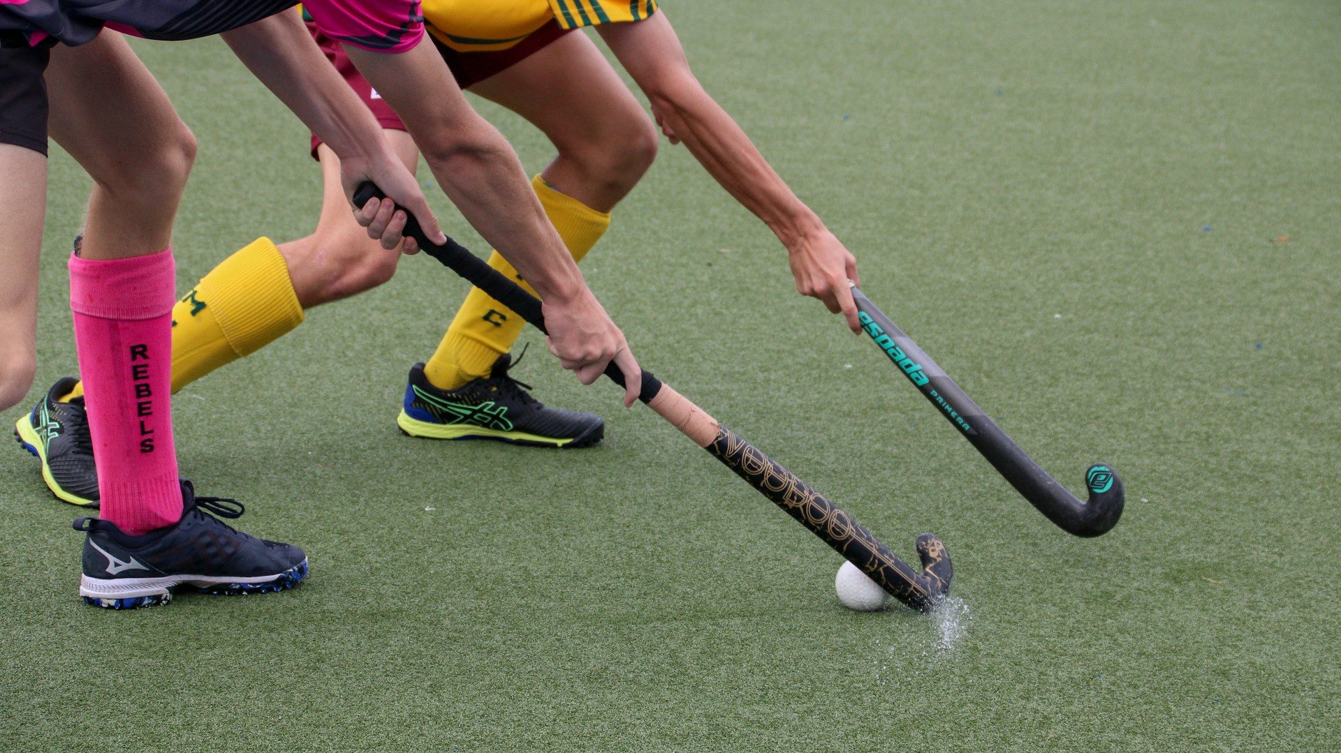 Pakistan Hockey Team Reward Disappointment Sparks Outrage – Two field hockey players intensely compete for the ball on a turf field, symbolizing the struggles and frustration linked with national sports disappointments.
