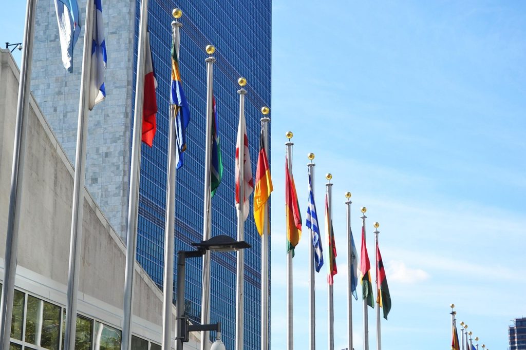 Pakistan Takes Over UN Security Council Leadership in July 2025 – Flags of member nations fly outside the United Nations headquarters building under a clear blue sky.