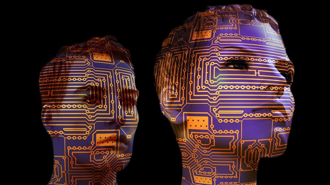 Two human-like mannequin faces illuminated with circuit board patterns, symbolising artificial intelligence, digital identity, and human-machine integration.