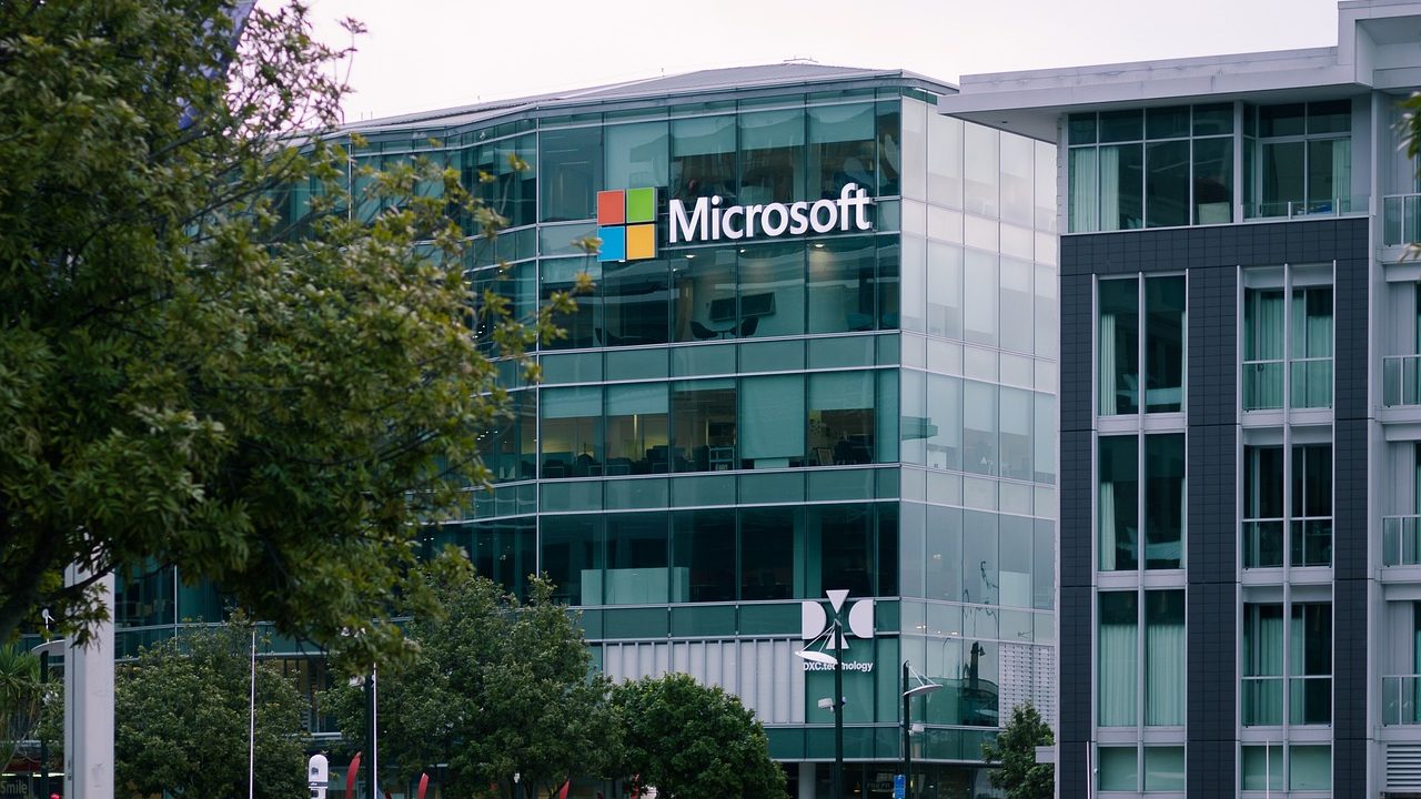 Microsoft Closes Office in Pakistan Amid Global Restructuring – A view of Microsoft’s glass-fronted regional office building, surrounded by trees and modern architecture.