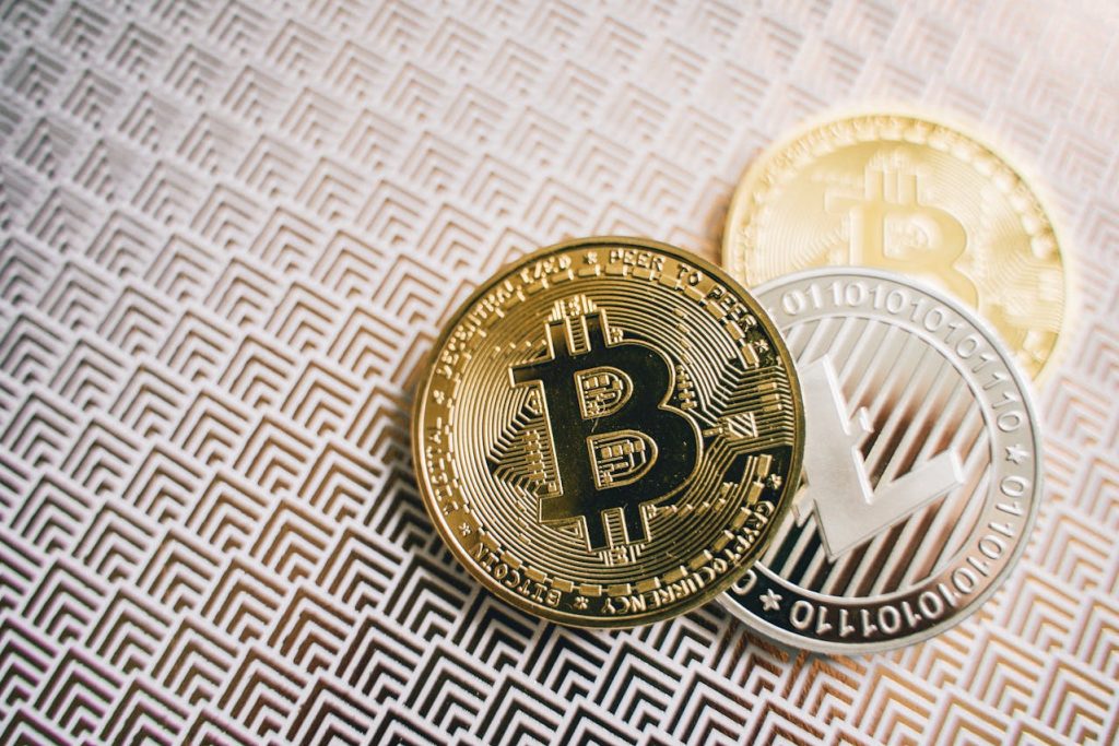 Close-up of physical Bitcoin and Litecoin coins placed on a patterned surface, symbolizing cryptocurrency, digital finance, and the regulation of digital assets in Pakistan.