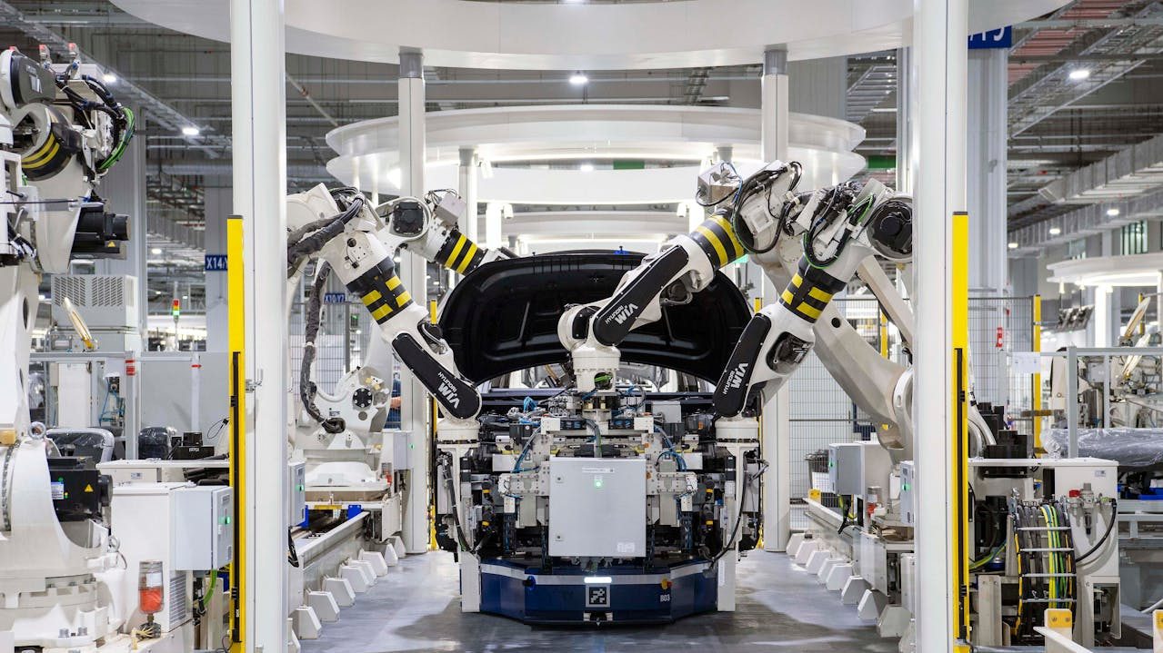 Automated robotic arms assemble an electric vehicle on a high-tech production line inside a modern factory, representing BYD's upcoming car assembly operations planned for Pakistan by 2026.