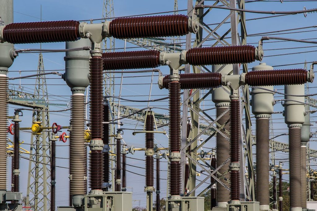 Electrical substation infrastructure showing high-voltage insulators and transmission equipment, representing the rising electricity prices due to low consumption.