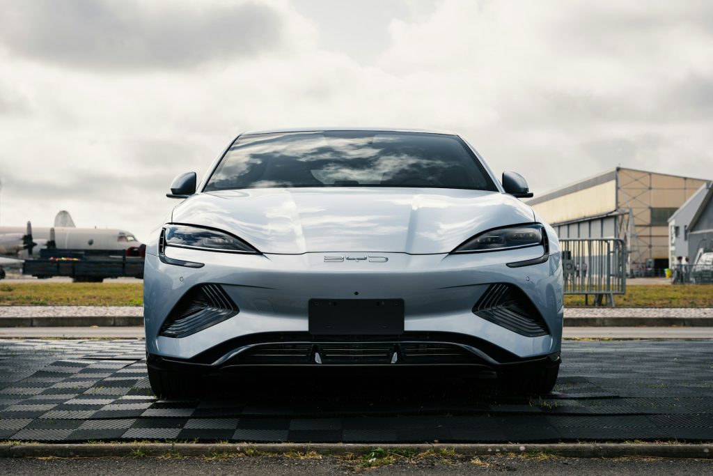 Front view of a sleek, silver BYD electric vehicle parked outdoors under a cloudy sky, symbolizing the expansion of Chinese EV giant BYD, which plans to begin car assembly in Pakistan by 2026.